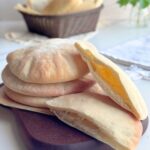 Easy homemade pita bread with a soft pocket shown cut open.