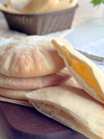 Easy homemade pita bread with a soft pocket shown cut open.