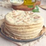 Stack of homemade Greek pita flatbreads on a plate