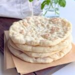 Soft no yeast stovetop pita bread stacked on a wooden board
