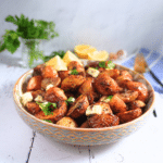 Easy Garlic And Lemon Roast Potatoes - Greek-Style served in a bowl with feta and olives