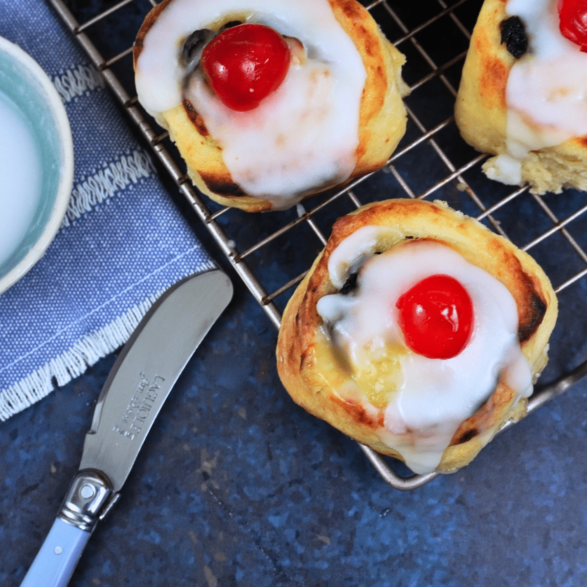 lemon curd rolls topped with glace icing and cherry