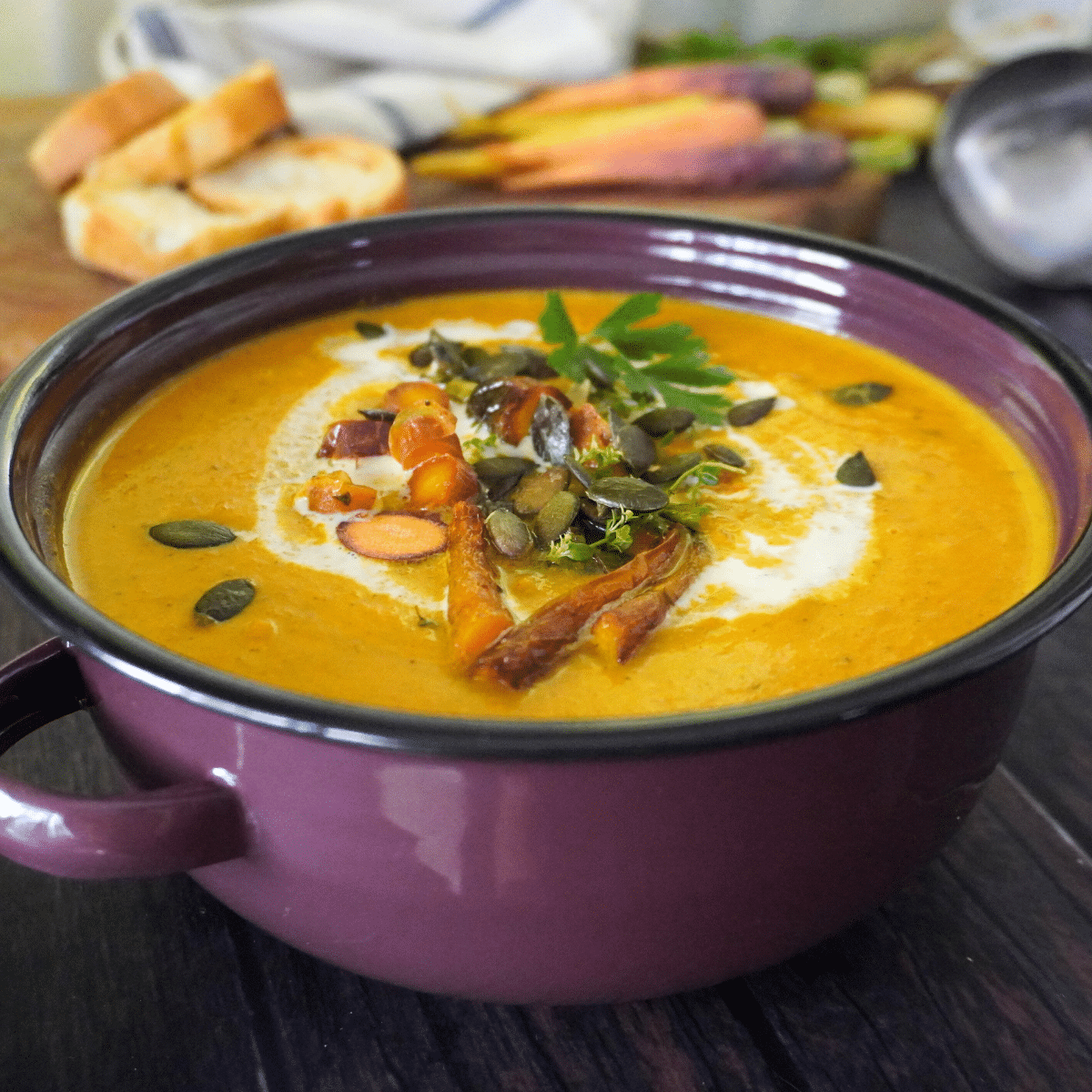 This roasted butternut squash and carrot soup combines sweet vegetables, fresh herbs, rich cream, and a hint of chili spice, all topped with crunchy pumpkin seeds