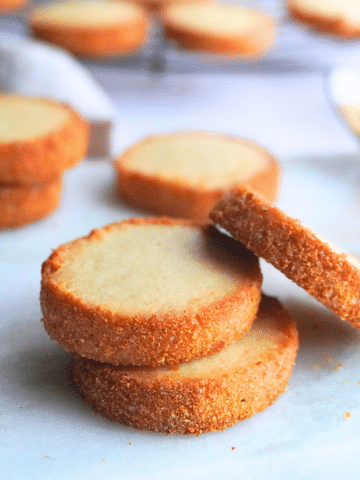Stacked sour cream butter cookies showing off their crispy, golden edges.