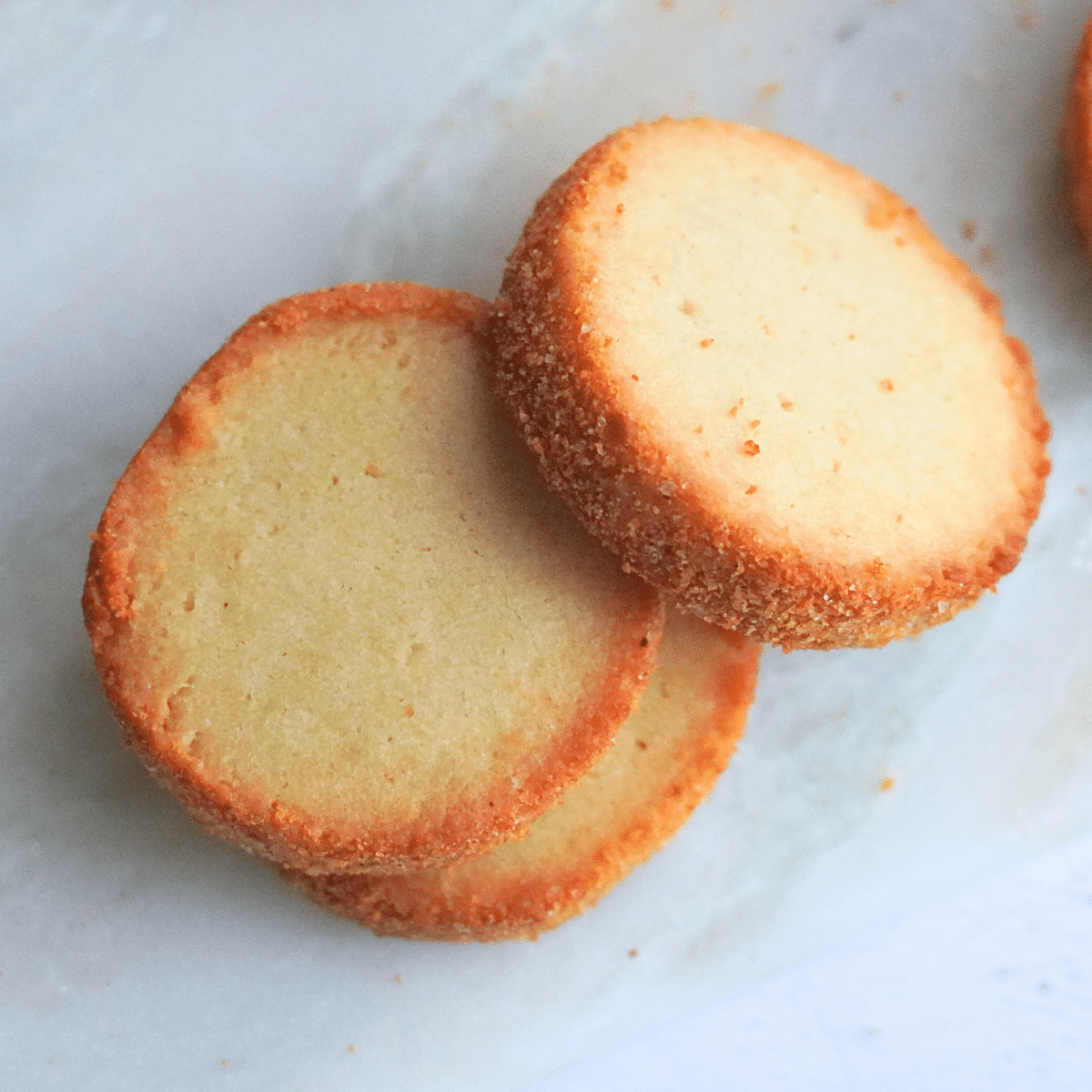 Top view of stacked sour cream butter cookies, showcasing their golden, crispy edges.