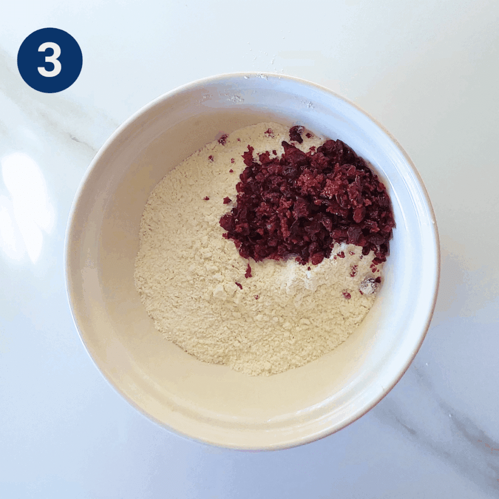 Cranberries added to flour mixture in a bowl