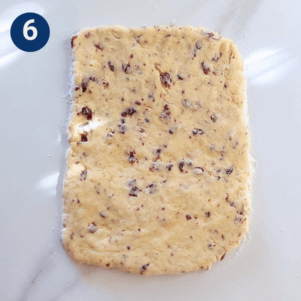 Dough patted into a rectangle on a floured surface