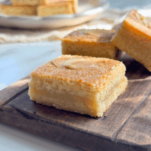 French almond cookie bars with a soft almond filling and golden top, sliced and served on a wooden board.