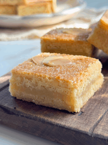 French almond cookie bars with a soft almond filling and golden top, sliced and served on a wooden board.