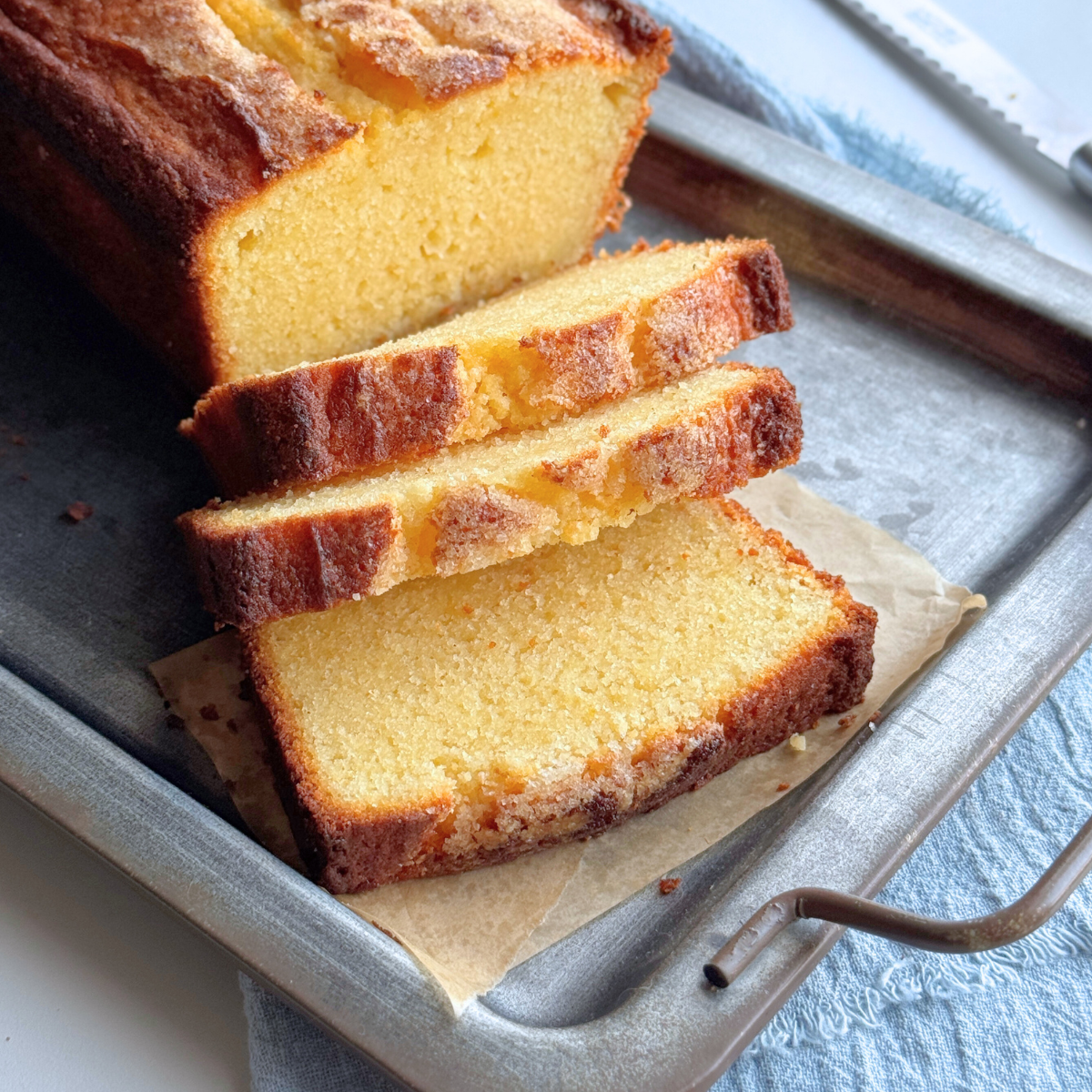 Sliced sour cream pound cake showing soft buttery crumb and golden sugar crust