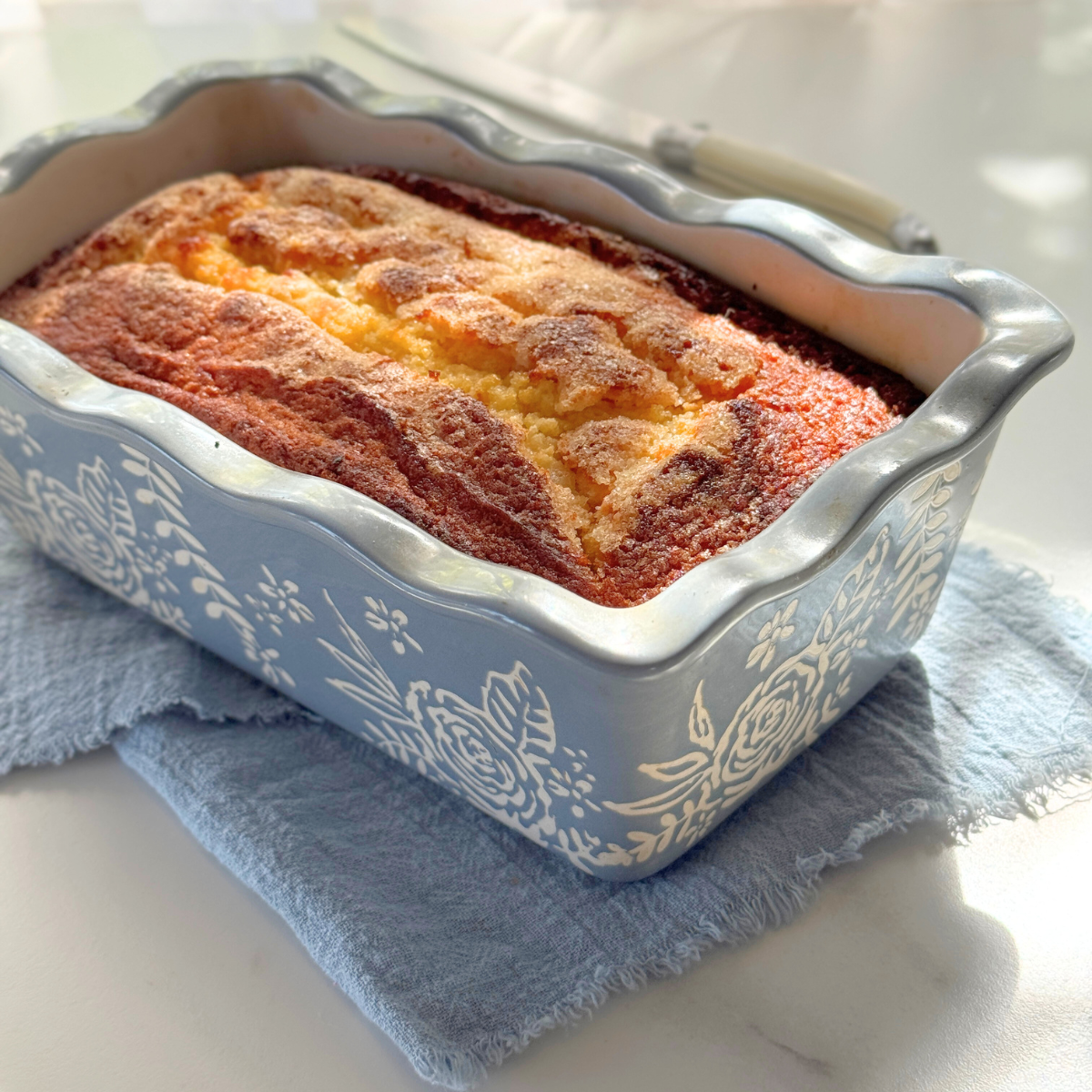 Whole loaf of sour cream pound cake with golden sugar crust on top