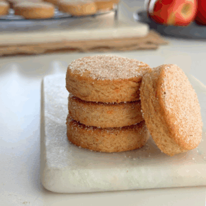Apple fritter butter cookies stacked with one cookie leaning to show sugar topping