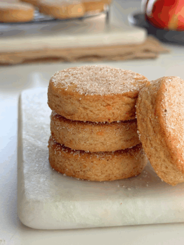 Apple fritter butter cookies stacked with one cookie leaning to show sugar topping