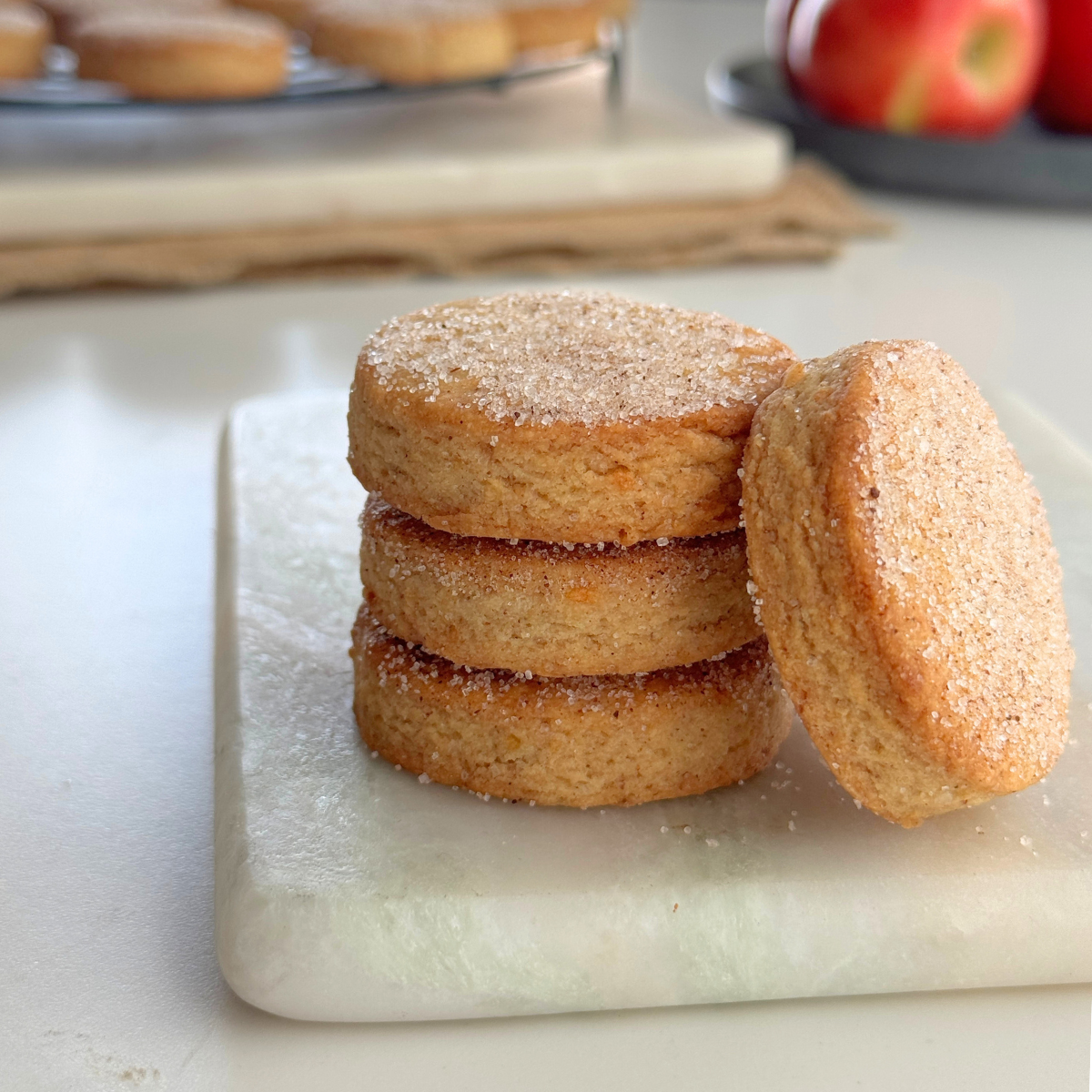 Apple fritter butter cookies stacked with one cookie leaning to show sugar topping