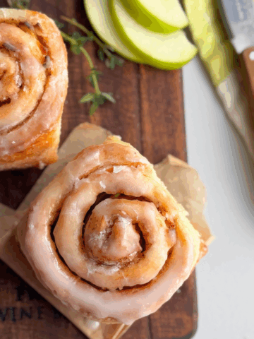 Glazed no yeast apple cinnamon roll showing golden spiral and shiny glaze