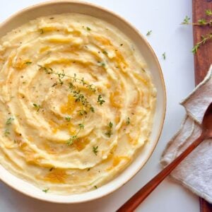 Top view of French onion mashed potatoes swirled with caramelized onions and garnished with fresh thyme.