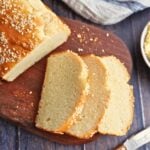 Sliced no-yeast quick bread with a golden top and sesame seeds on a wooden board