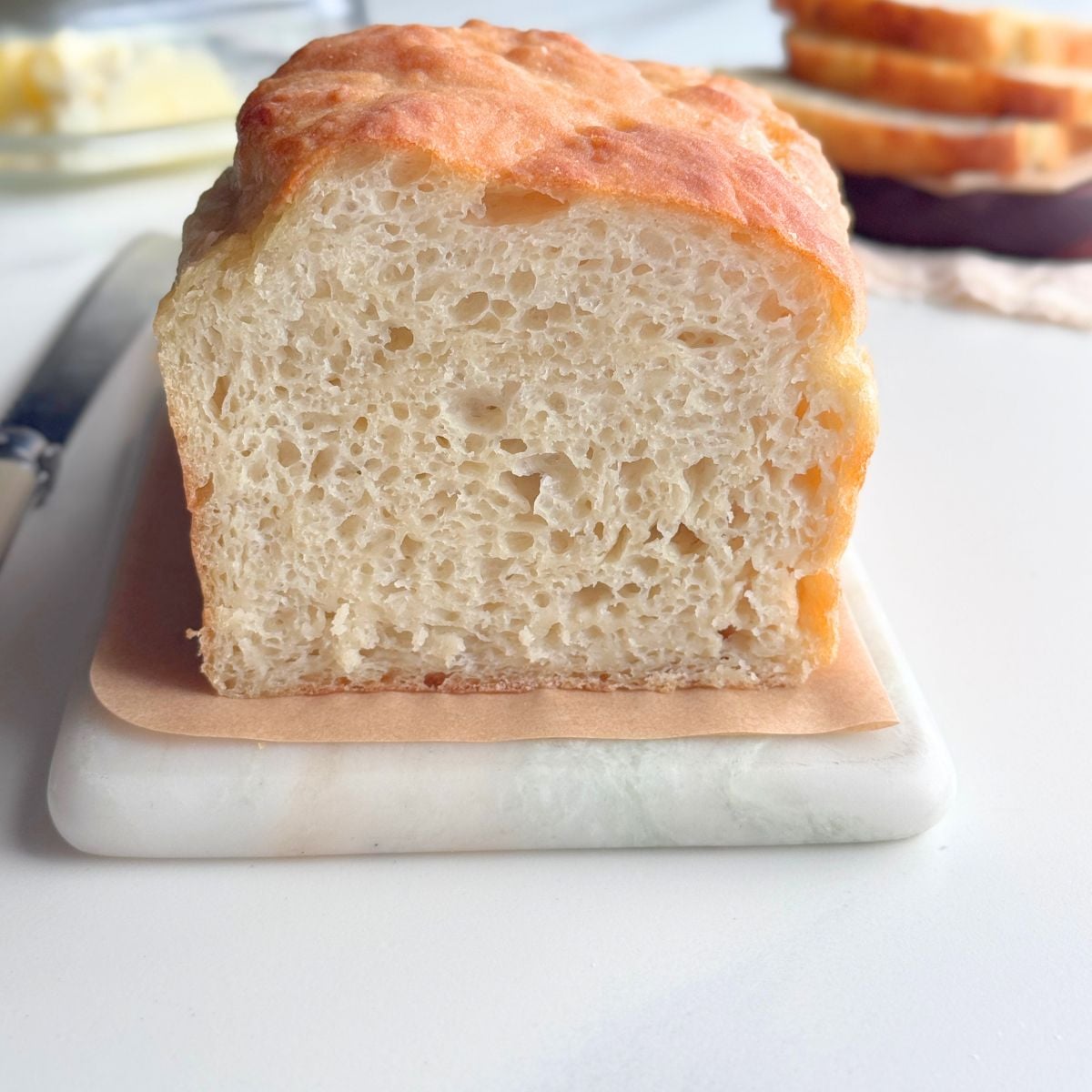 No knead bread loaf with soft airy crumb sliced on a board