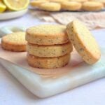 Lemon poppy seed butter cookies stacked on white marble board