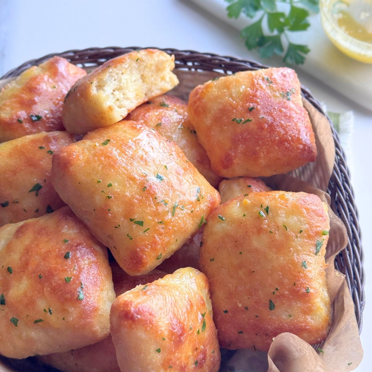 Close-up of quick no-knead garlic butter potato rolls in a basket, showing the soft fluffy interior and garlic butter glaze.