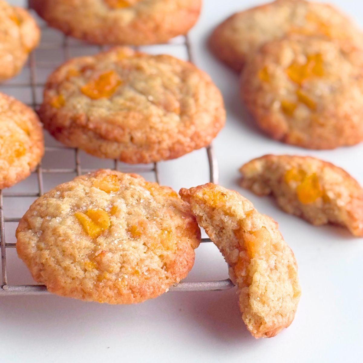 Peach cookies on cooling rack with half on the side to show texture