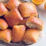 Orange poppy seed no-knead buns brushed with orange butter in a basket.
